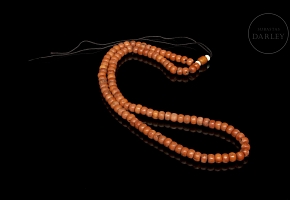 Bag with 180 coral-coloured beads, 20th century